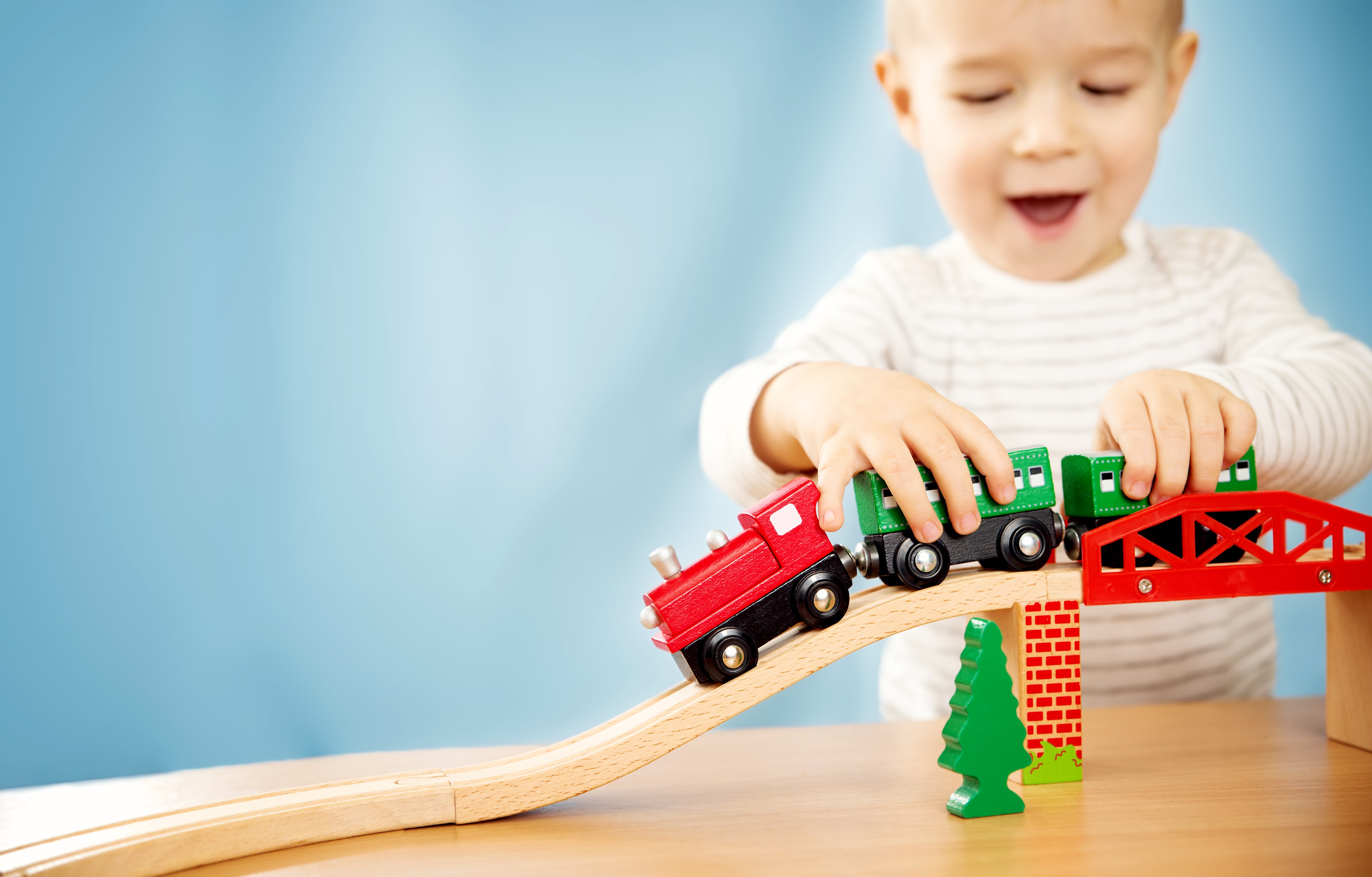 little boy playing with trains